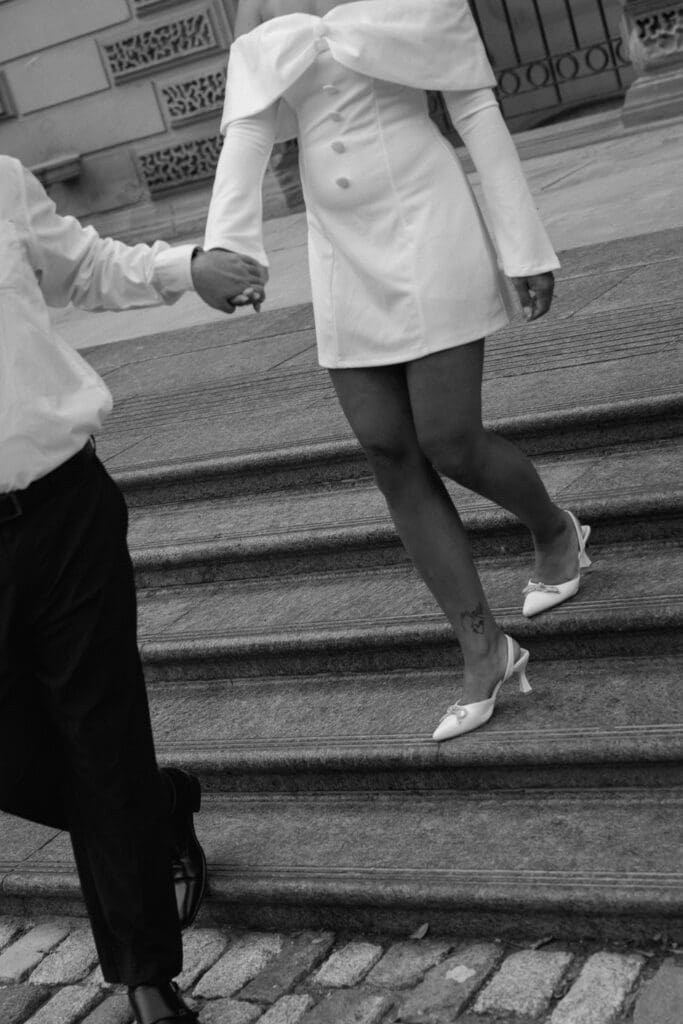 Cheyanne and Keegan holding hands while walking through Osgoode Hall courtyard in Toronto