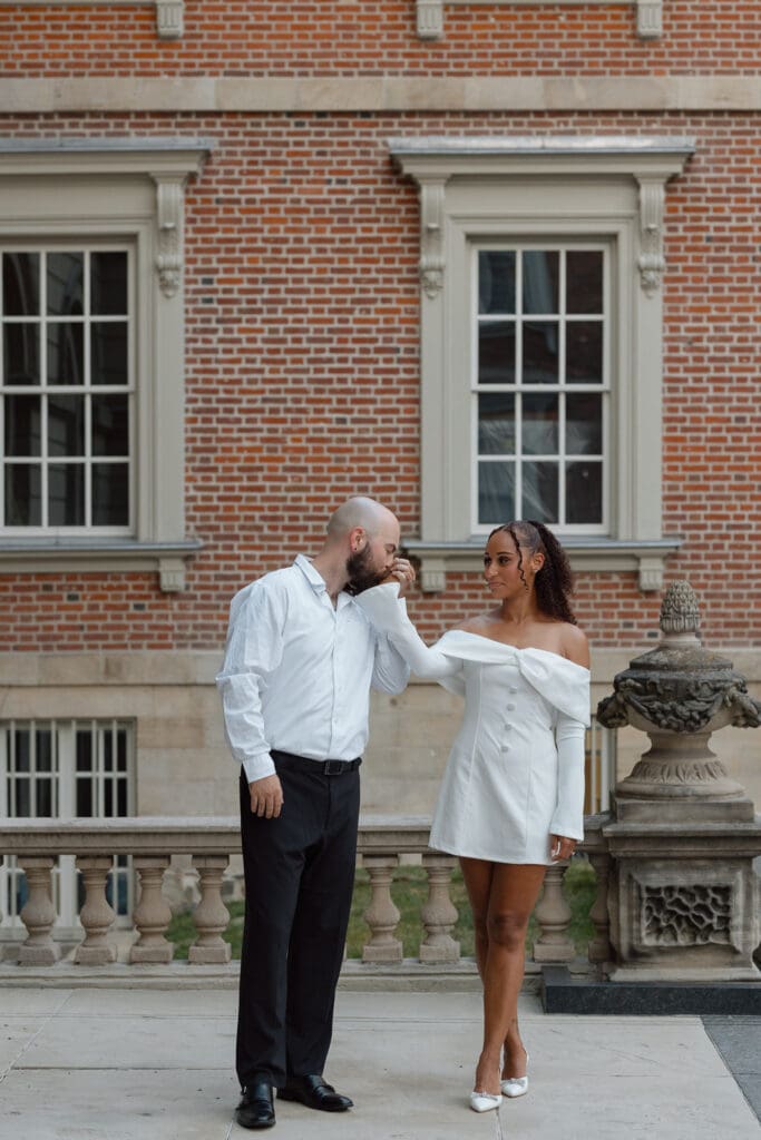 Joyful engagement photo of Cheyanne and Keegan smiling at each other outside Osgoode Hall