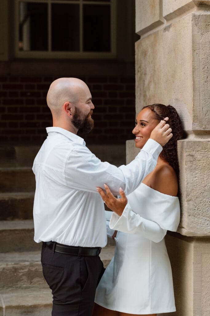 Cheyanne and Keegan smiling at each other during their romantic Osgoode Hall engagement photos
