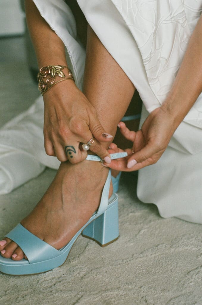Bride wearing blue heels while getting ready on her wedding day

