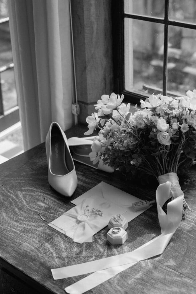 Bridal shoes bouquet and wedding details by a window
