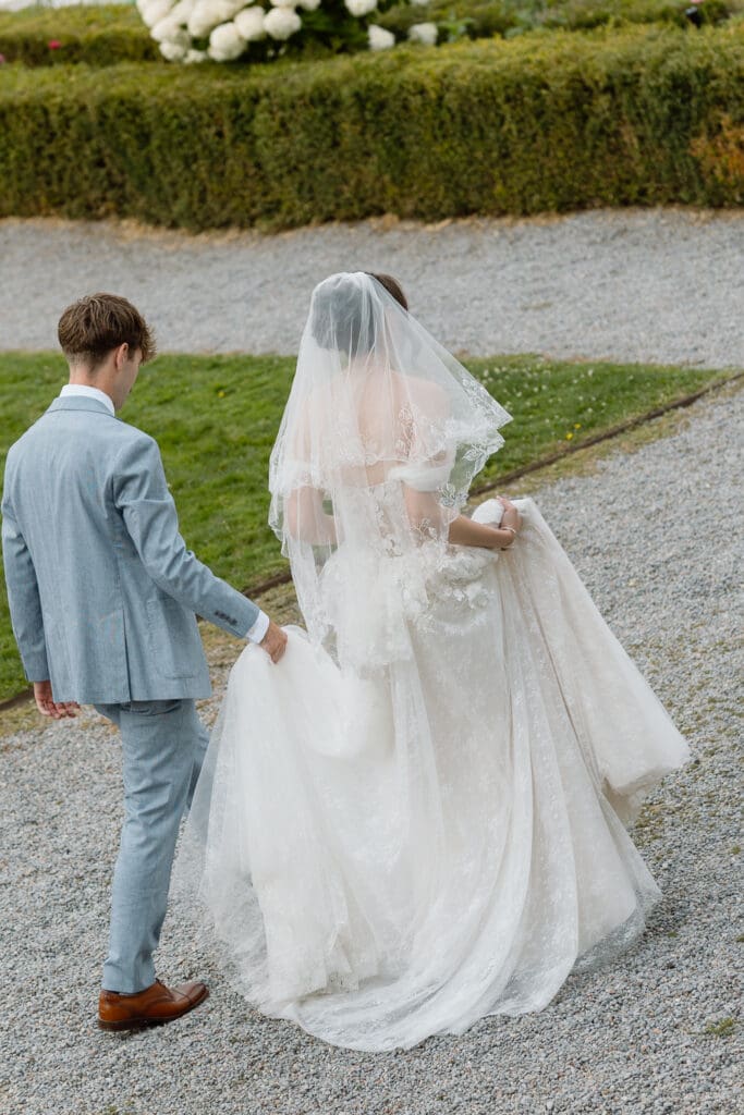 Bride and groom walking beside the formal gardens at Parkwood Estate
