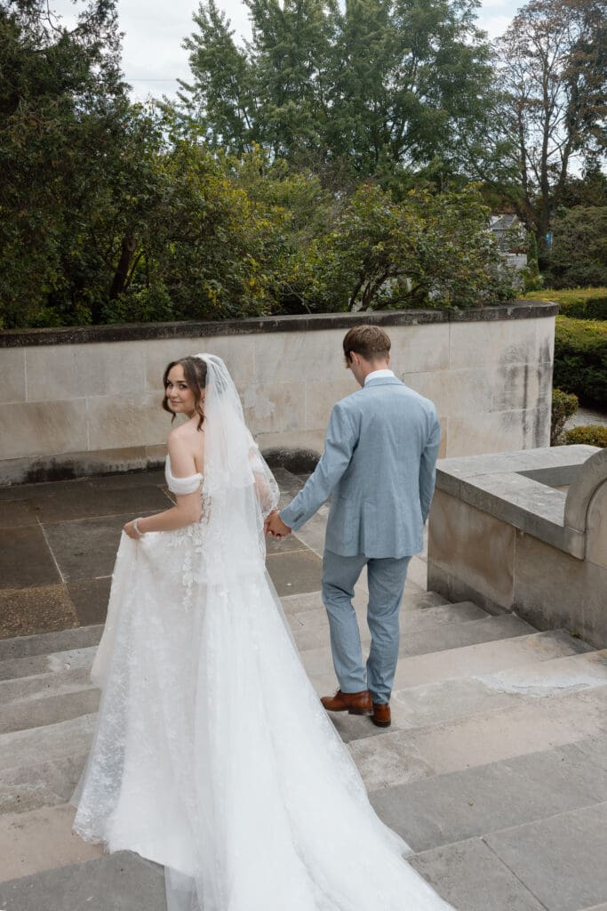 Bride and groom walking through the gardens at Parkwood Estate in Oshawa, Ontario
