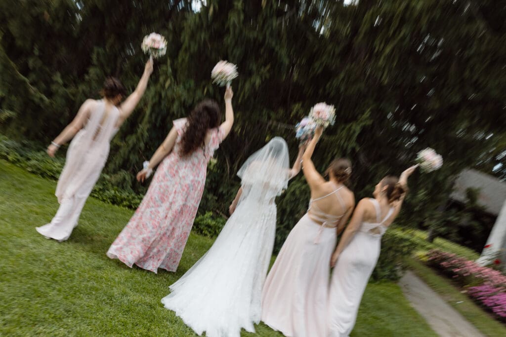 Bridesmaids and Bride walking with bouquet in the air