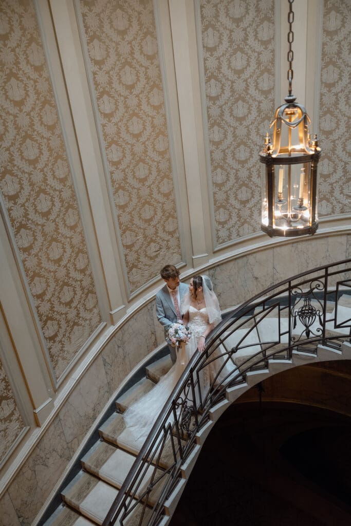 Bride and groom standing together on the historic staircase inside Parkwood Estate
