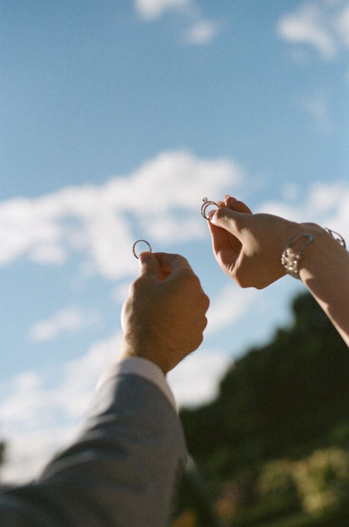 Wedding details photographed on 35mm film against a blue sky
